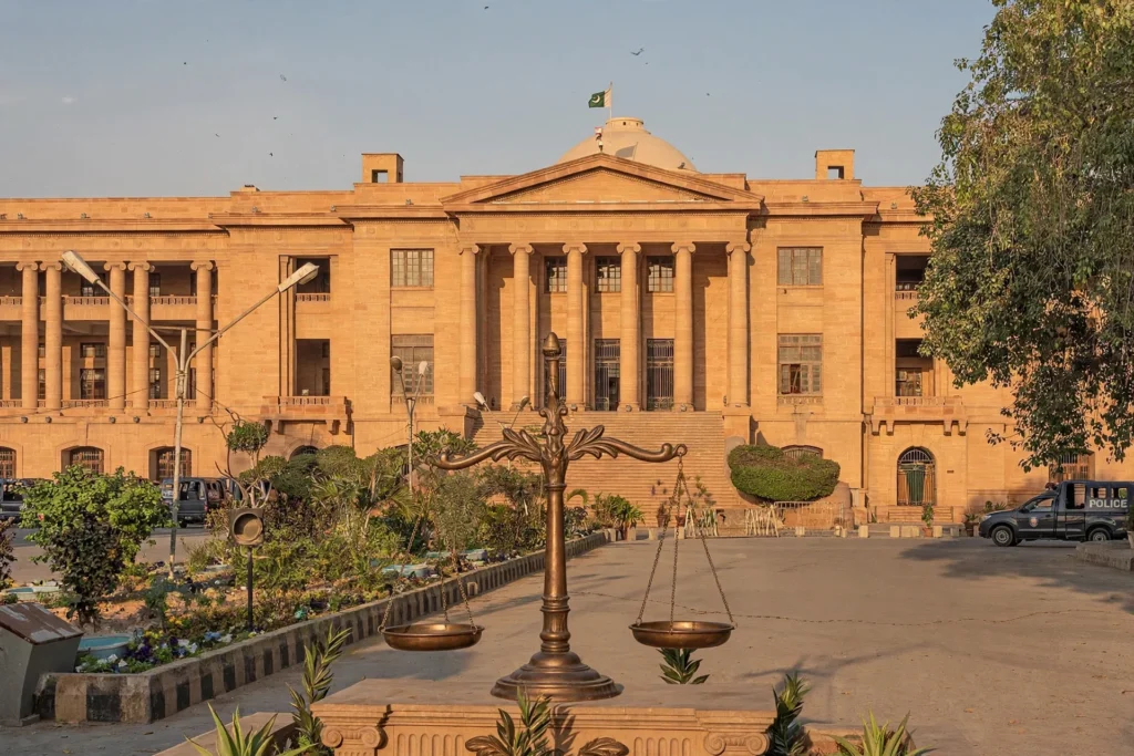 کراچی کی ایک عدالت کی عمارت اور انصاف کے ترازو کی علامتی تصویر (کسی اصل شخص کی تصویر نہیں)