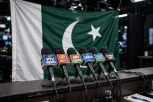 کراچی میں سانحہ کارساز کی 19ویں برسی کے موقع پر پریس کانفرنس — مائیکروفونز کے سامنے قومی پرچم