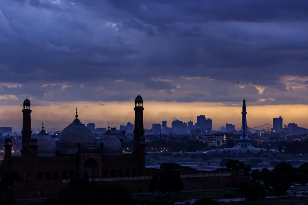 اے آئی سے بنی تصویر — فلڈ لائٹس میں ہاکی اسٹیڈیم، سبز شرٹس والے کھلاڑی گول کی خوشی مناتے ہوئے (اصل شخصیات کی شباہت نہیں)