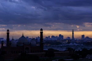 اے آئی سے بنی تصویر — فلڈ لائٹس میں ہاکی اسٹیڈیم، سبز شرٹس والے کھلاڑی گول کی خوشی مناتے ہوئے (اصل شخصیات کی شباہت نہیں)